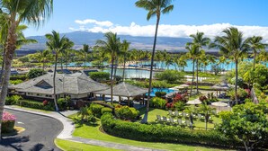 A resort with a pool area, palm trees, and a view of the mountains. - 3 BR penthouse with easy beach access - Hilton Waikoloa Access Included (Waikoloa)