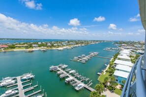 A marina with boats docked, a clear sky, and buildings along the waterfront.