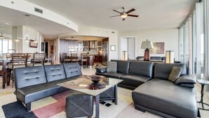 Ein großzügiger Wohnbereich mit einer Couch, einem Couchtisch und einem Essbereich im Hintergrund.