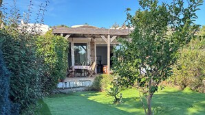 A well-maintained lawn with a wooden pergola and a dining area with outdoor furniture.