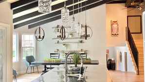 A spacious kitchen with a central island, pendant lighting, and a modern staircase.