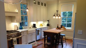 A kitchen with white cabinets, a wooden island, a stove, and a sink. - Walk to AVL's TOP restaurants, pubs, etc. Ashehville’s historic Falconhurst area (Asheville)