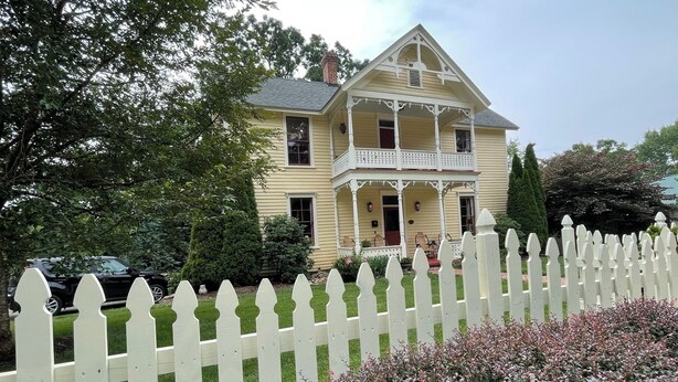 A two-story house with a balcony, surrounded by a white picket fence and greenery. - Walk to AVL's TOP restaurants, pubs, etc. Ashehville’s historic Falconhurst area (Asheville)