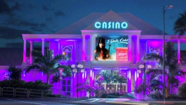 A building with a prominent 'CASINO' sign, a large illuminated billboard, and a symmetrical facade with columns. - Skys Villa to Shoelcher (Schoelcher)