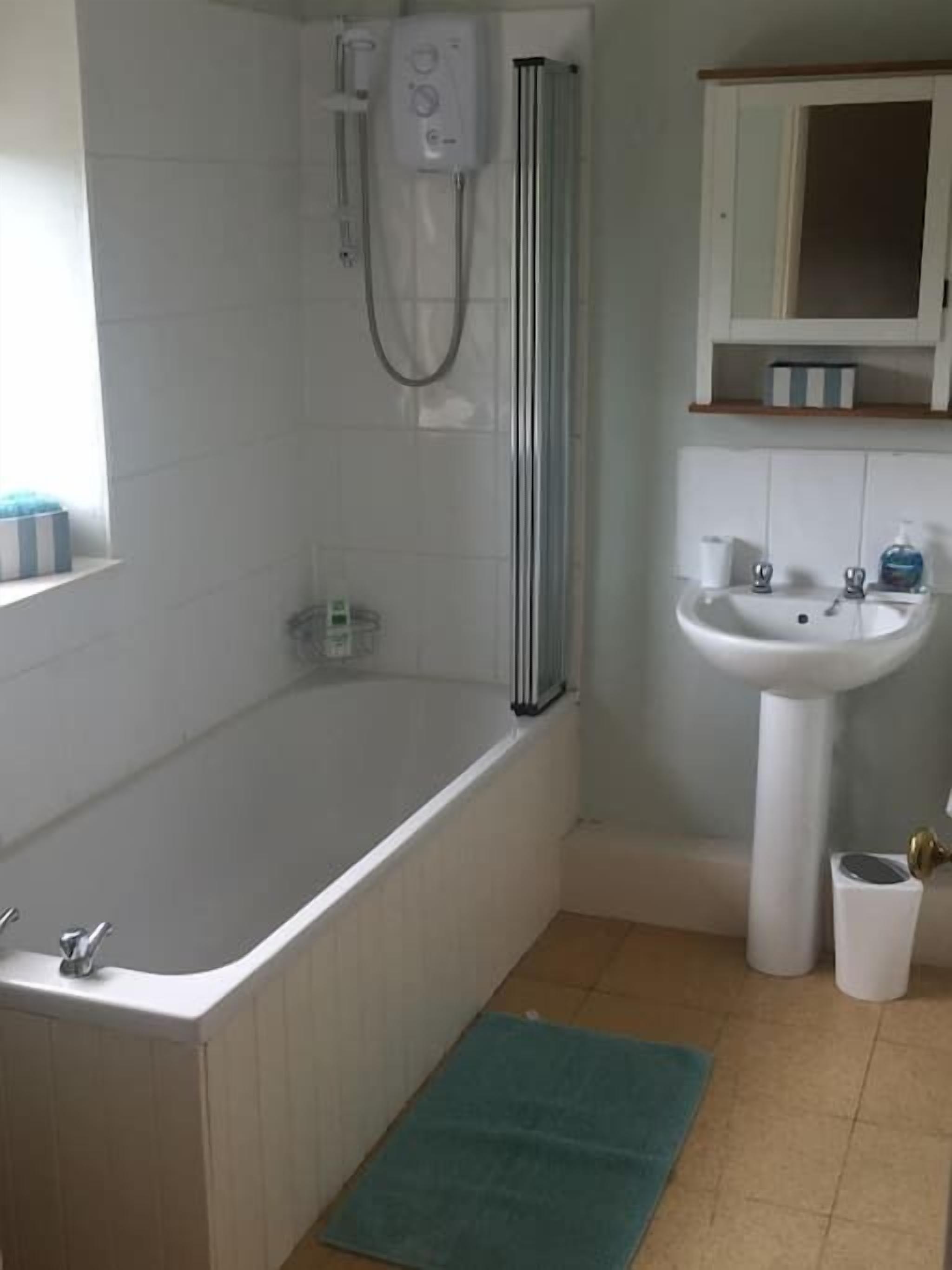 Ein Badezimmer mit Badewanne, Dusche, Waschbecken und Toilette.