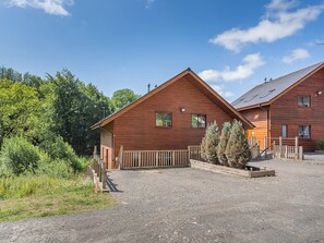 Eine Holzhütte mit einem Schotterweg und einem Holzzaun.