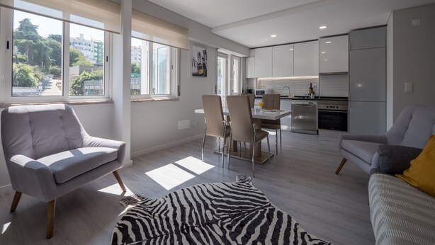 A modern apartment with a dining area, kitchen, and seating space.