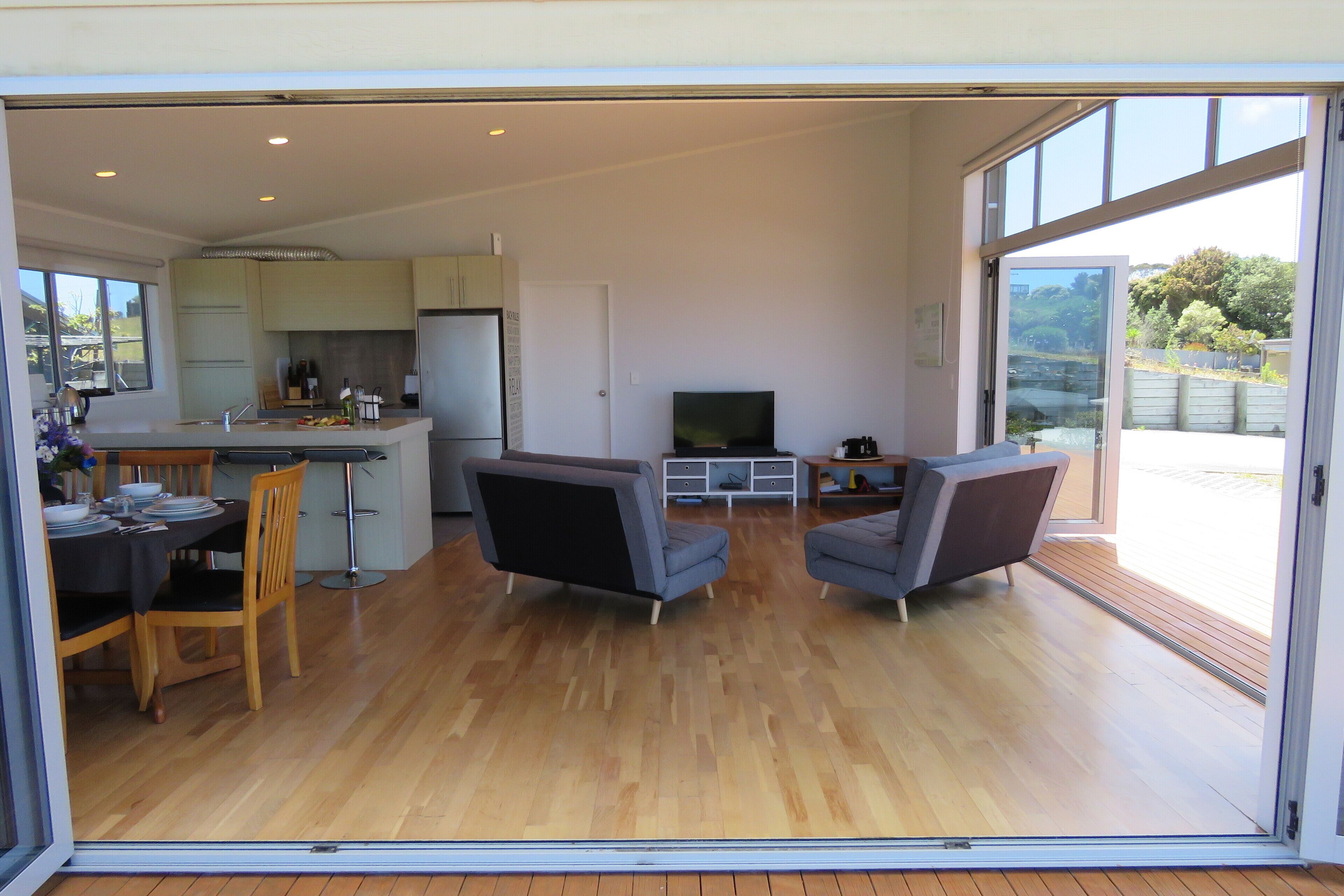 A modern open-plan living area with a kitchen, dining table, and seating.