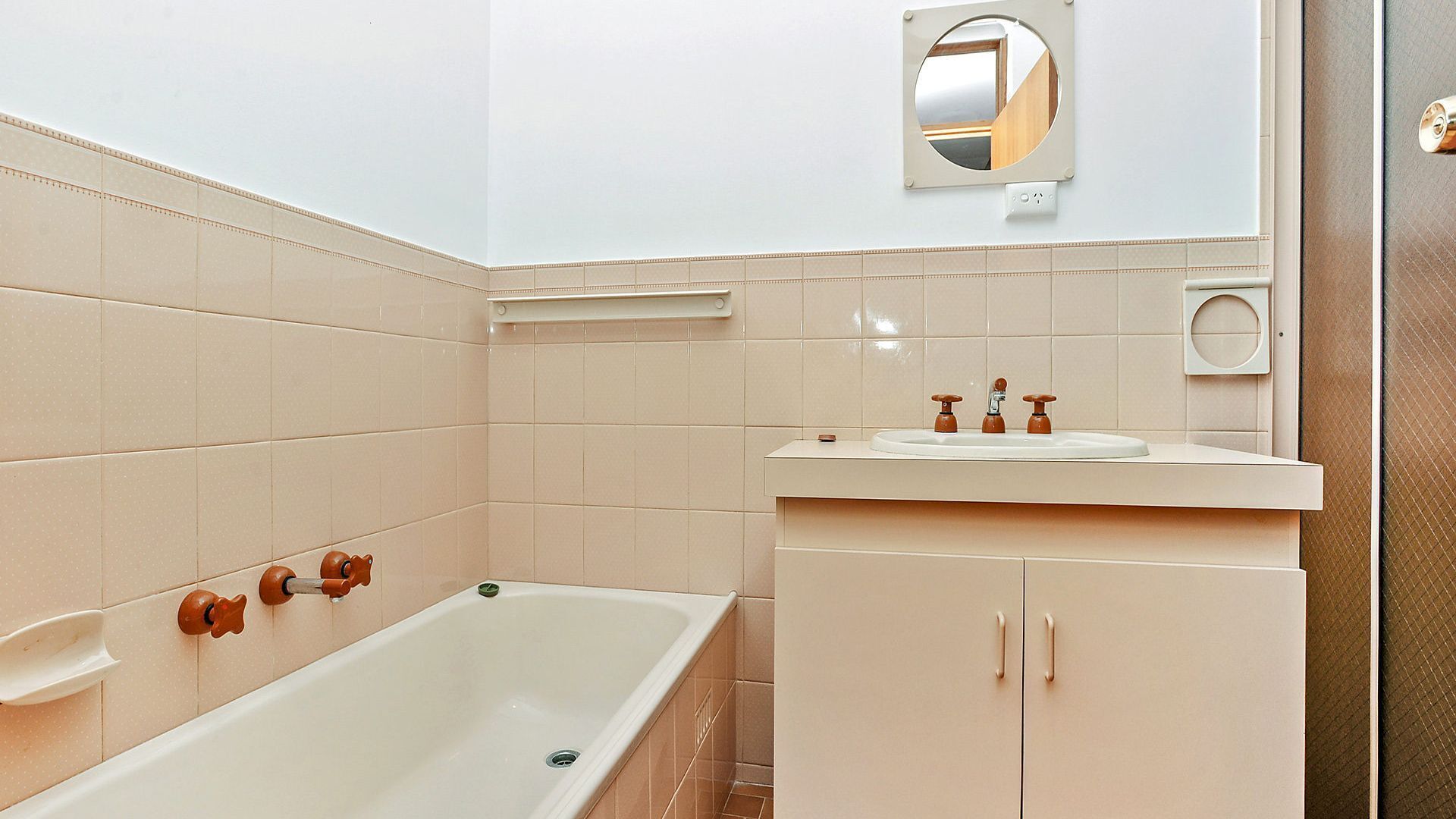 A bathroom with a bathtub, a sink, and a mirror.