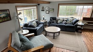 A cozy living room with a wooden bench, two sofas, a round coffee table, and a rug.