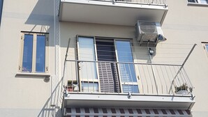 Een meerhoog gebouw met balkons, luifels en airconditioners.