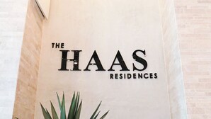 A reception area with a sign reading "The Haas Residences" and a potted plant. - The Haas, Trademark Collection by Wyndham (Los Angeles)