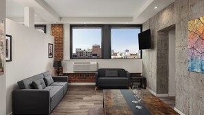 A modern living room with a sofa, a coffee table, and a TV. - The Haas, Trademark Collection by Wyndham (Los Angeles)