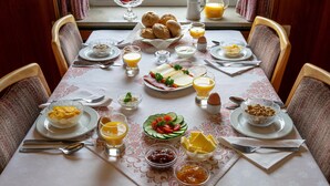 A breakfast table set with various dishes, including eggs, bread, and fruit. - B&B Sauerland TCF (Willingen)