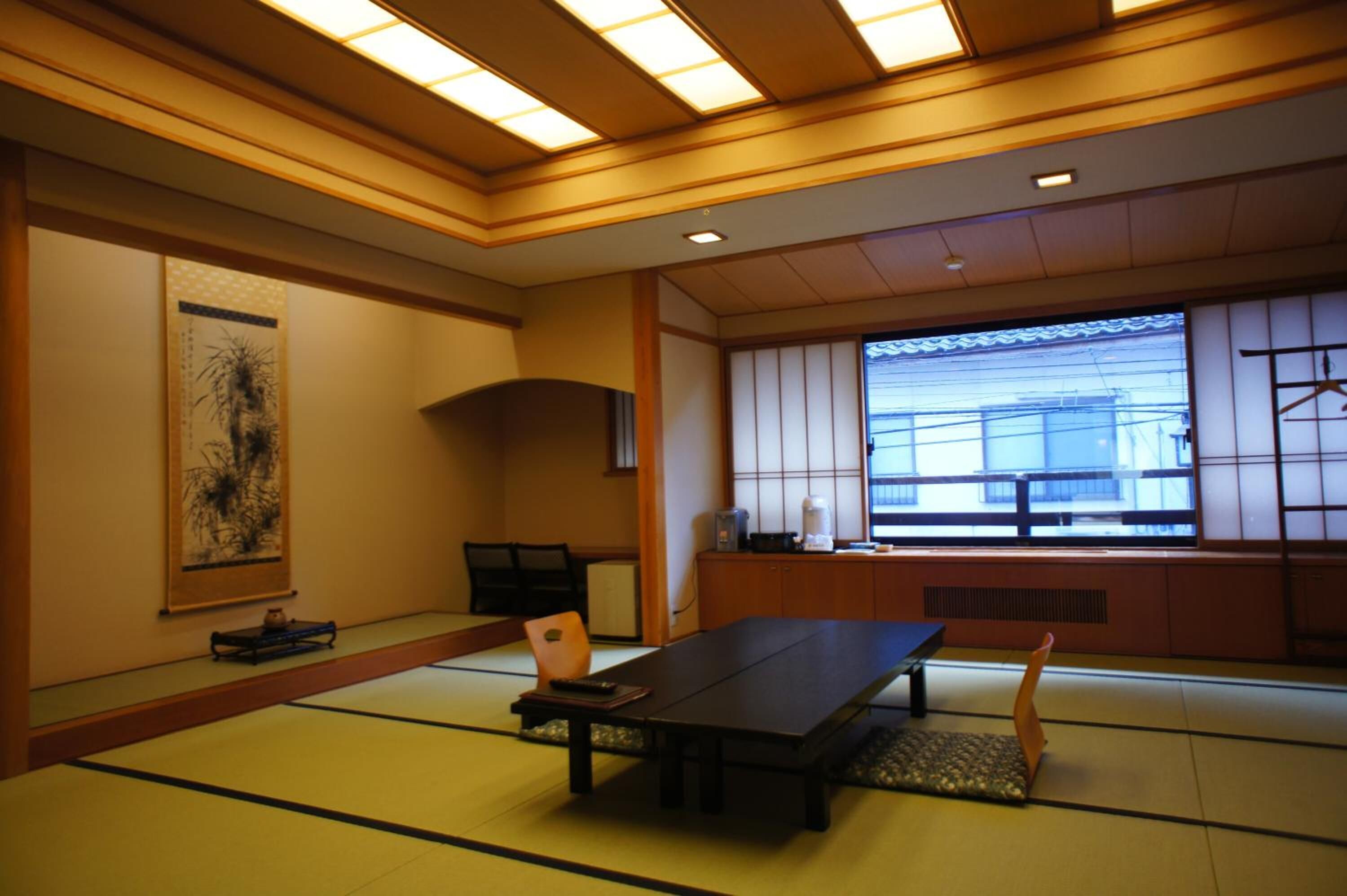 Une pièce de style japonais traditionnel, avec un sol recouvert de tatamis, une table basse et une porte coulissante.