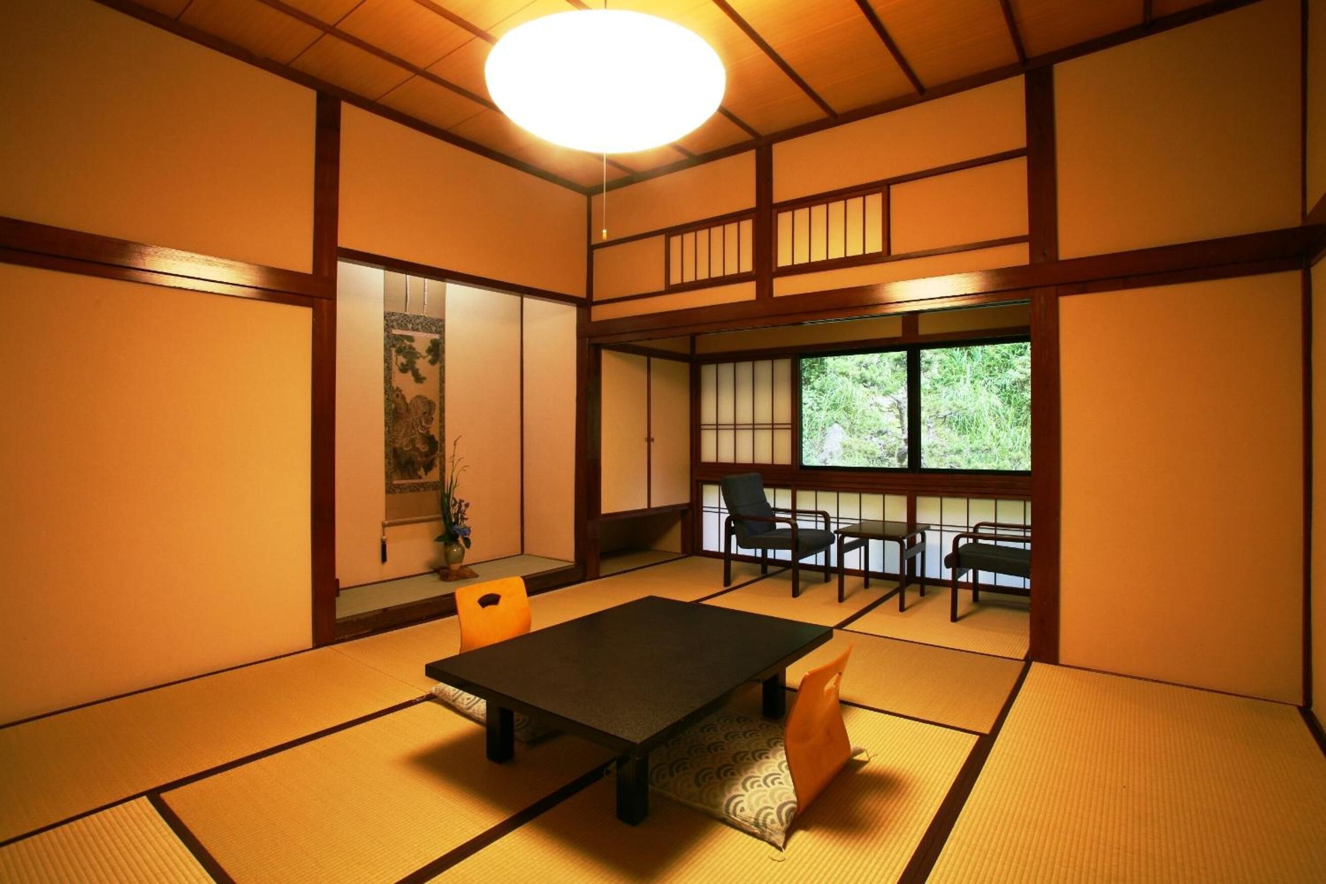 A traditional Japanese room with tatami flooring, a low table, and sliding doors.