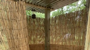 A bamboo-walled shower area with a built-in toilet and a sink. - Comfy Camping At The Palms (Old Town)