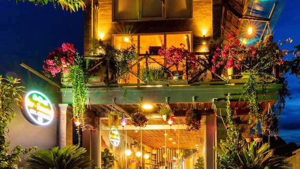 A hotel with a balcony, hanging plants, and a sign. - An Thai Bar & Homestay (Hoa Lu)