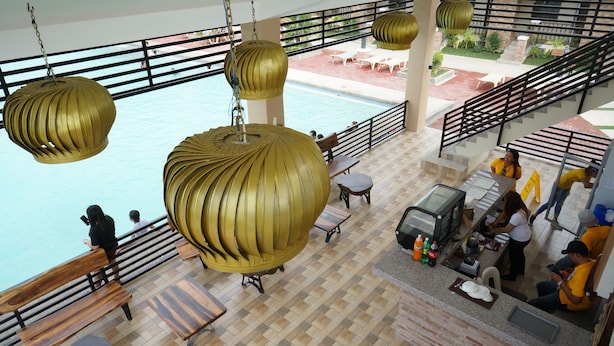 A spacious indoor area with a pool, wooden furniture, and hanging decorative lights. - Hacienda Galea Resort and Events Place (Baliuag)