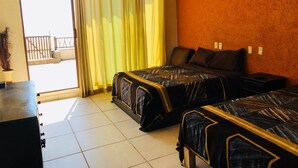 A hotel room with two beds, a balcony, and a view of the outside. - La Perla Playa Azul Bungalow #1 (Playa Azul)