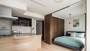 Ein modernes Apartment mit Küche, Essbereich und Schlafzimmer.
