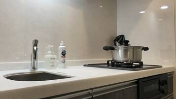 Una cucina con un lavello doppio, un fornello e due flaconi di sapone.