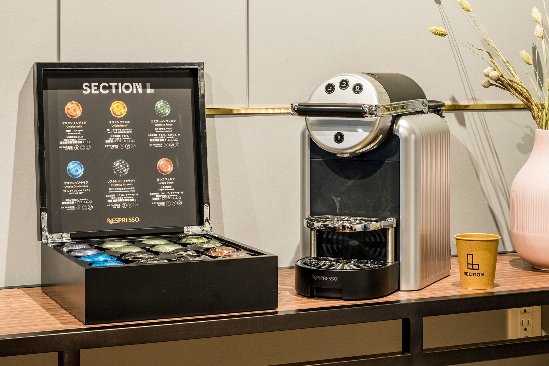 A coffee machine with a display of coffee pods and a cup of coffee on a counter.