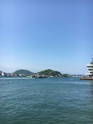A waterfront view with a dock, boats, and a mountainous backdrop. - Step Pier (Onomichi)