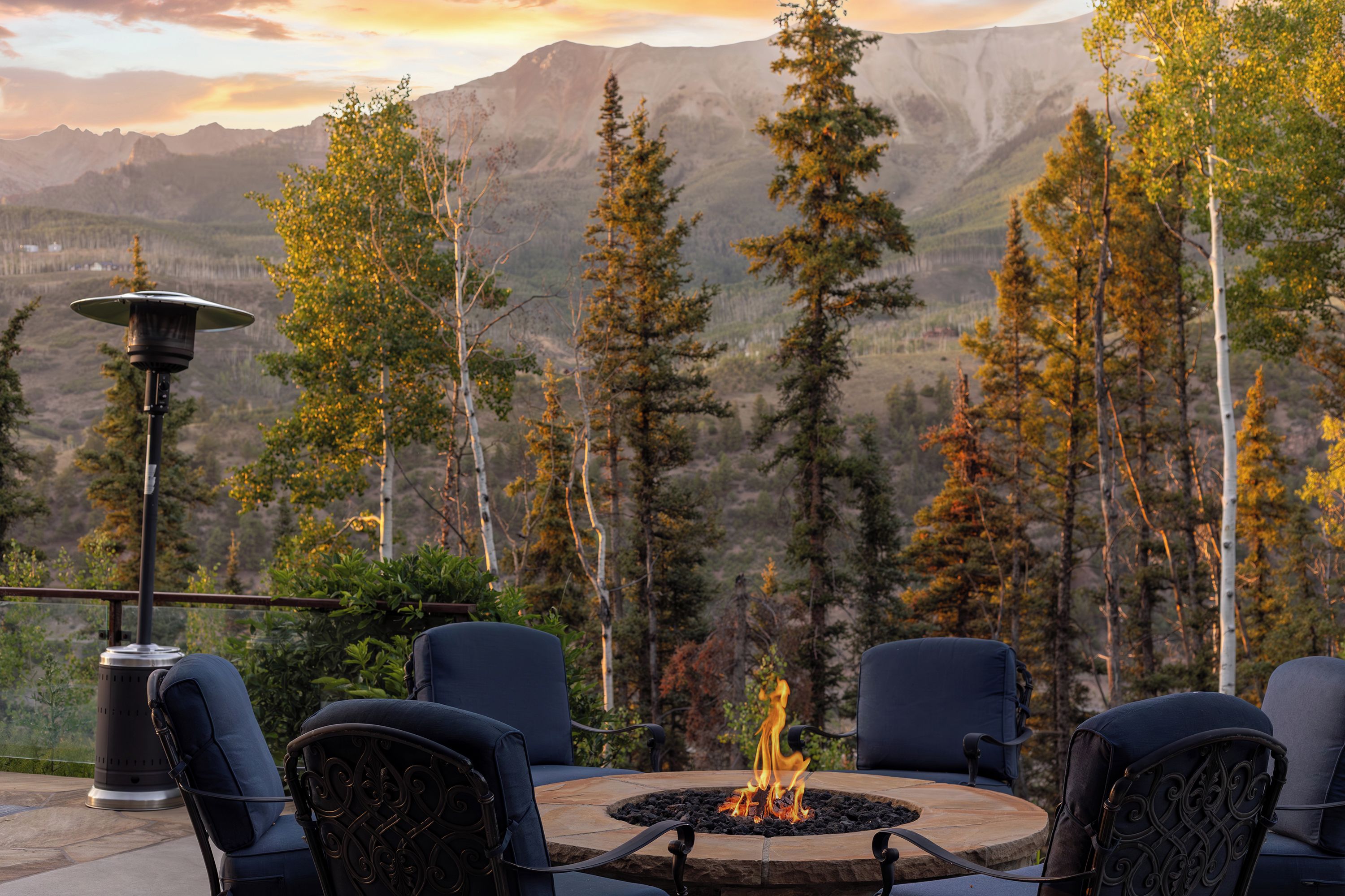 Un foyer avec des chaises disposées autour, offrant une vue sur un paysage montagneux.