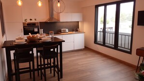 A modern kitchen with a dining area, large windows, and a view of the outdoors. - Apartment T3 located in front of the beach of QUIBERON. (QUIBERON)