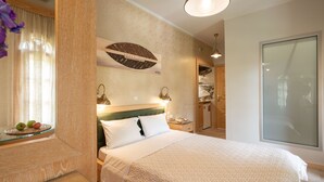 A hotel room with a bed, bedside tables, a mirror, a wall clock, and a window with curtains. - Villa Haroula (Parga)