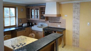 Une cuisine avec des meubles de rangement en bois, un évier et une fenêtre.
