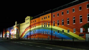 Un edificio con un mural de colores de arcoíris en su fachada.