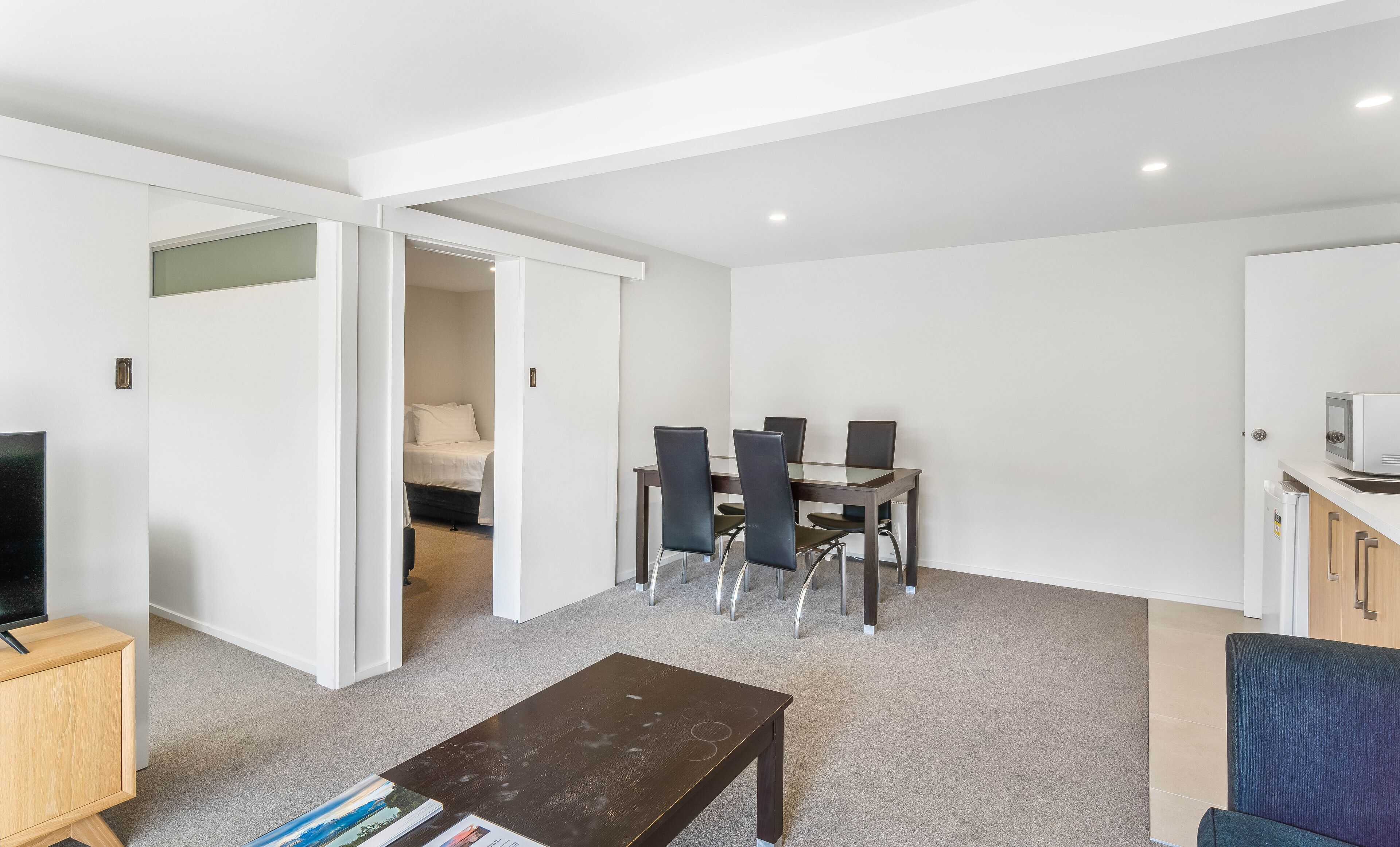 Eine moderne Wohnung mit Essbereich, kleiner Küche, Wohnzimmer und Schlafzimmer.