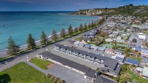 Une ville côtière dotée d’un port de plaisance, d’immeubles résidentiels et d’une route principale menant à la plage.