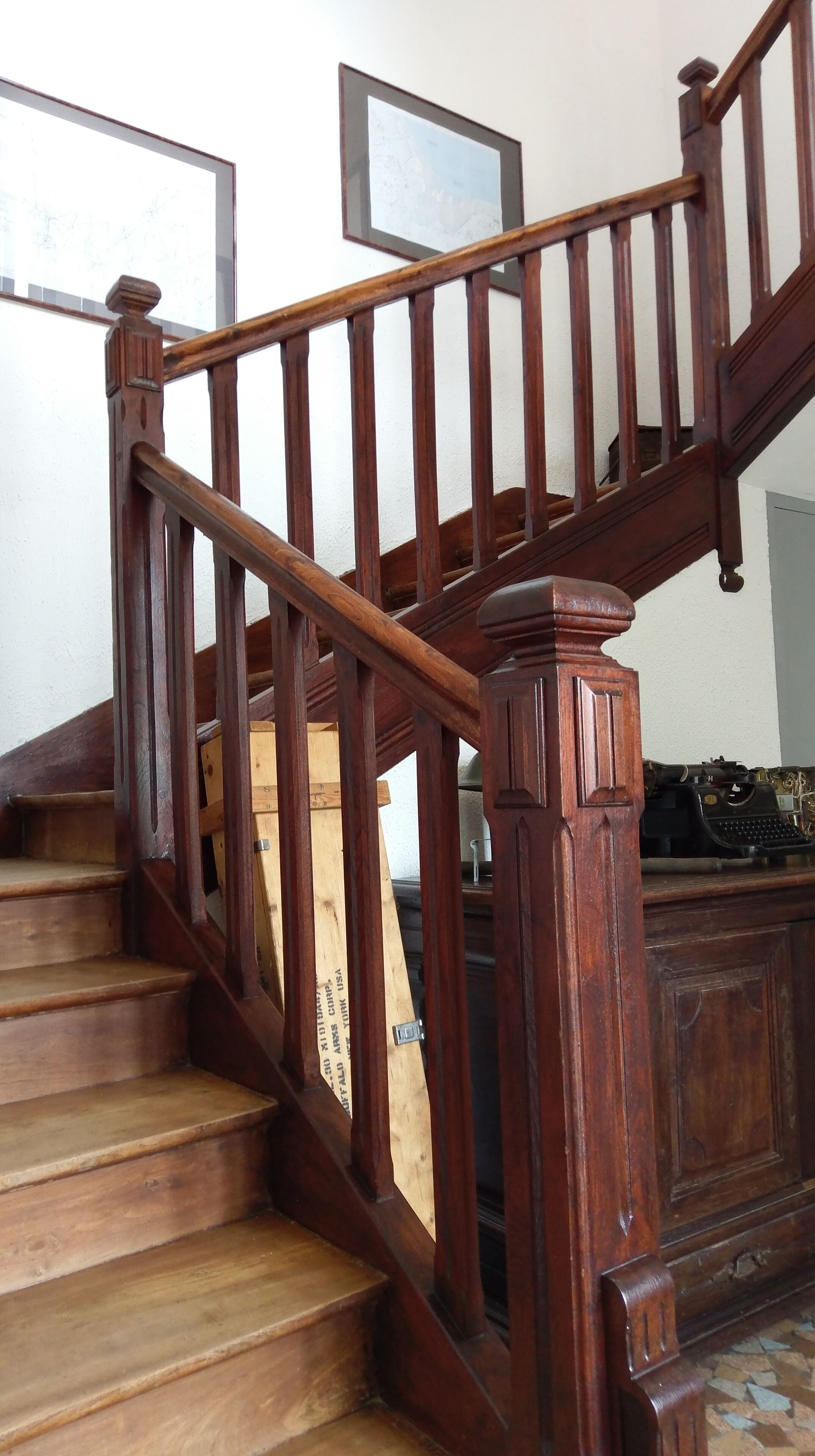 A wooden staircase with a handrail and a wooden banister.