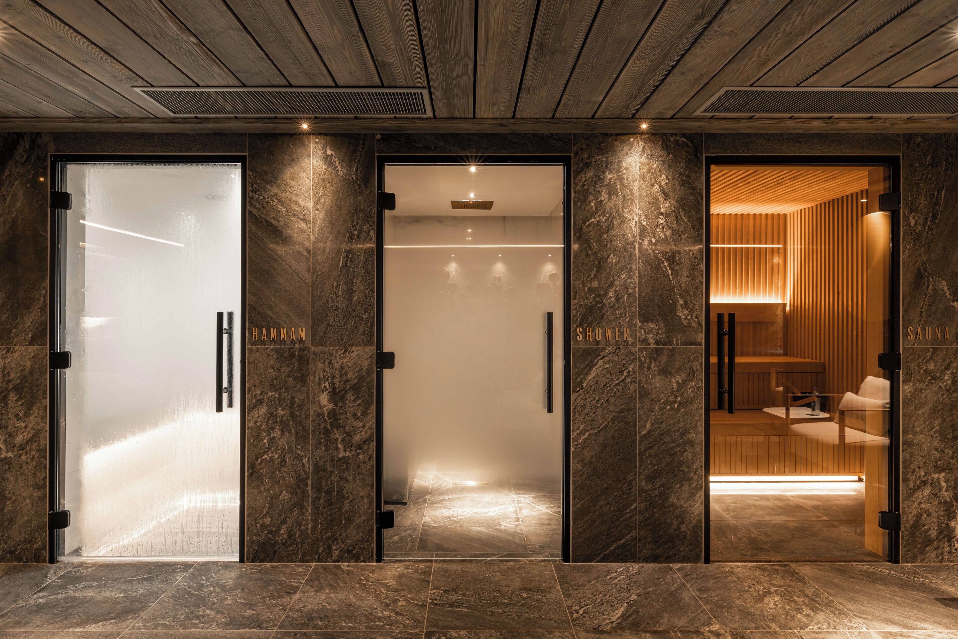 Un vestíbulo de hotel moderno con una puerta de cristal que indica 