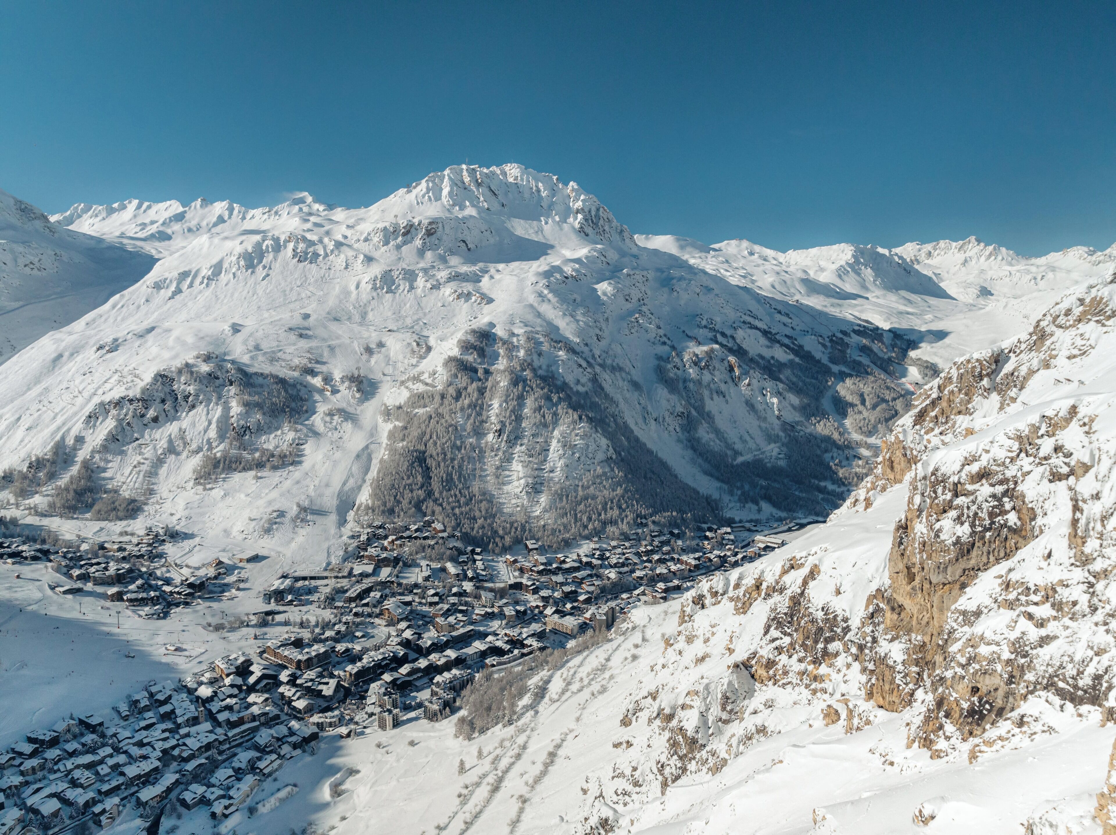 Un pueblo cubierto de nieve con edificios agrupados en un valle.