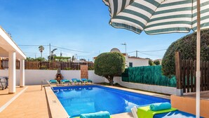 A swimming pool with lounge chairs and a pergola. - VILLA AMALIA Family chalet. Private Pool, Free AC / Wi-fi (Cala en Porter)