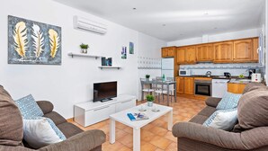 A modern apartment with a living room, dining area, and kitchen. - VILLA AMALIA Family chalet. Private Pool, Free AC / Wi-fi (Cala en Porter)