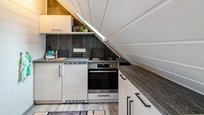 A compact kitchen with a built-in oven, a coffee maker, and a small countertop area.
