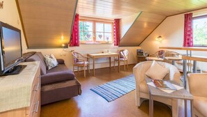 Una habitación acogedora con un sofá, una mesa de comedor y sillas.