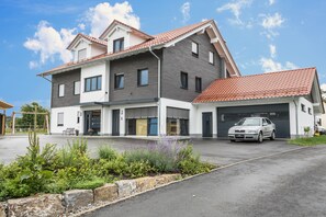 A two-story house with a garage, a driveway, and a car parked inside.