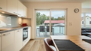 A modern kitchen with a sliding glass door leading to an outdoor patio area.