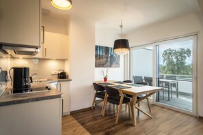 Una cocina moderna con zona de comedor, una cafetera y vistas al exterior.