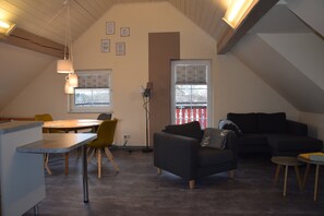 En modern inredning med ett matområde, en soffa och ett fönster med persienner.
