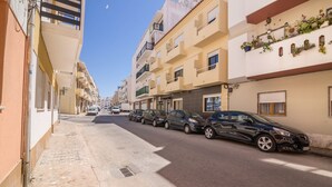 A street with parked cars and buildings with balconies. - "Beach Residence 21" with Balcony, Barbecue, Wi-Fi & Cable TV; Parking Available (Armação de Pera)