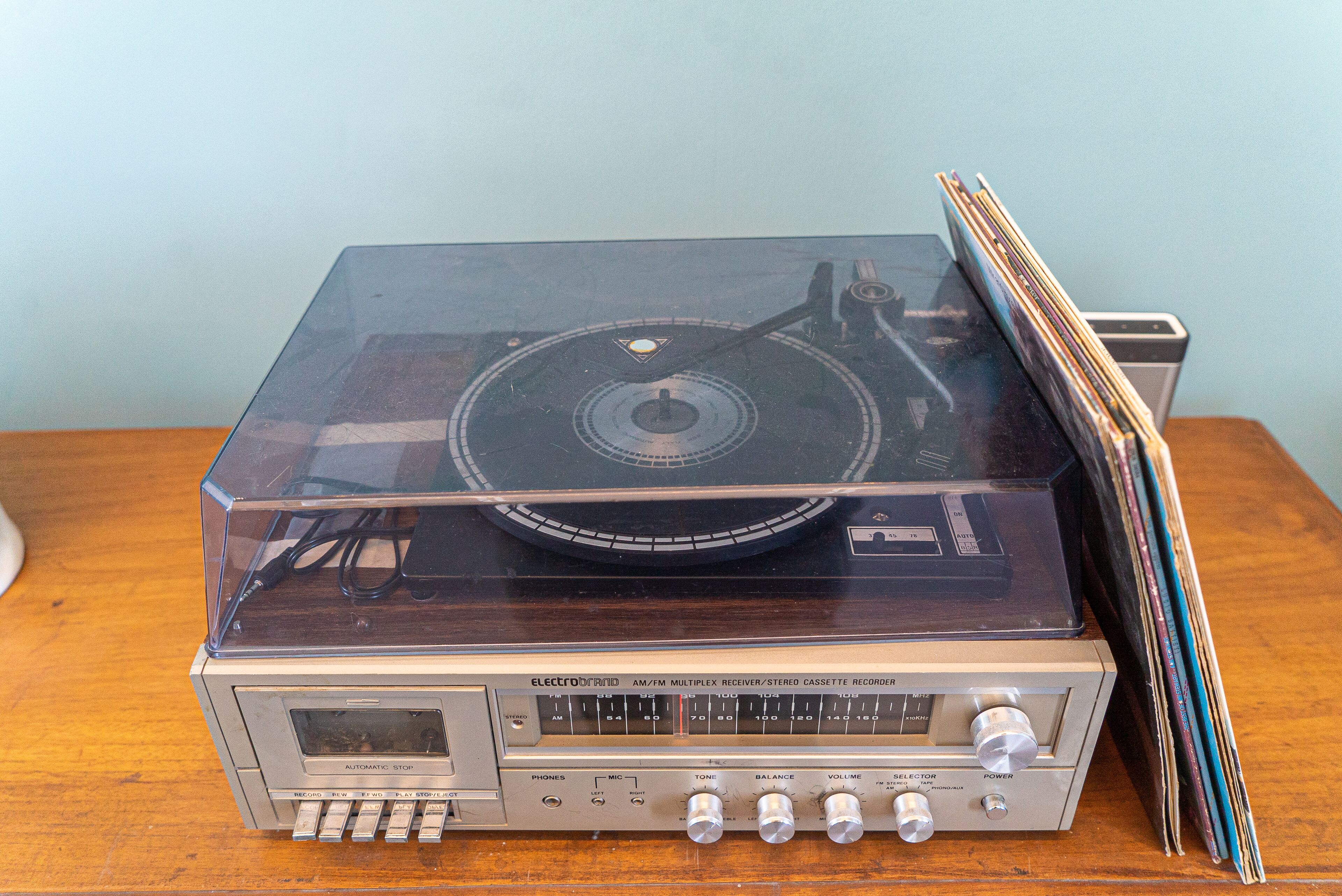 A vintage AM/FM multiplex receiver/record player with a transparent top, control knobs, and a cassette player below.
