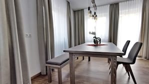 A modern dining area with a wooden table, bench, and chairs. - Whg.5 Ferienwohnung Landglück (Bechhofen)