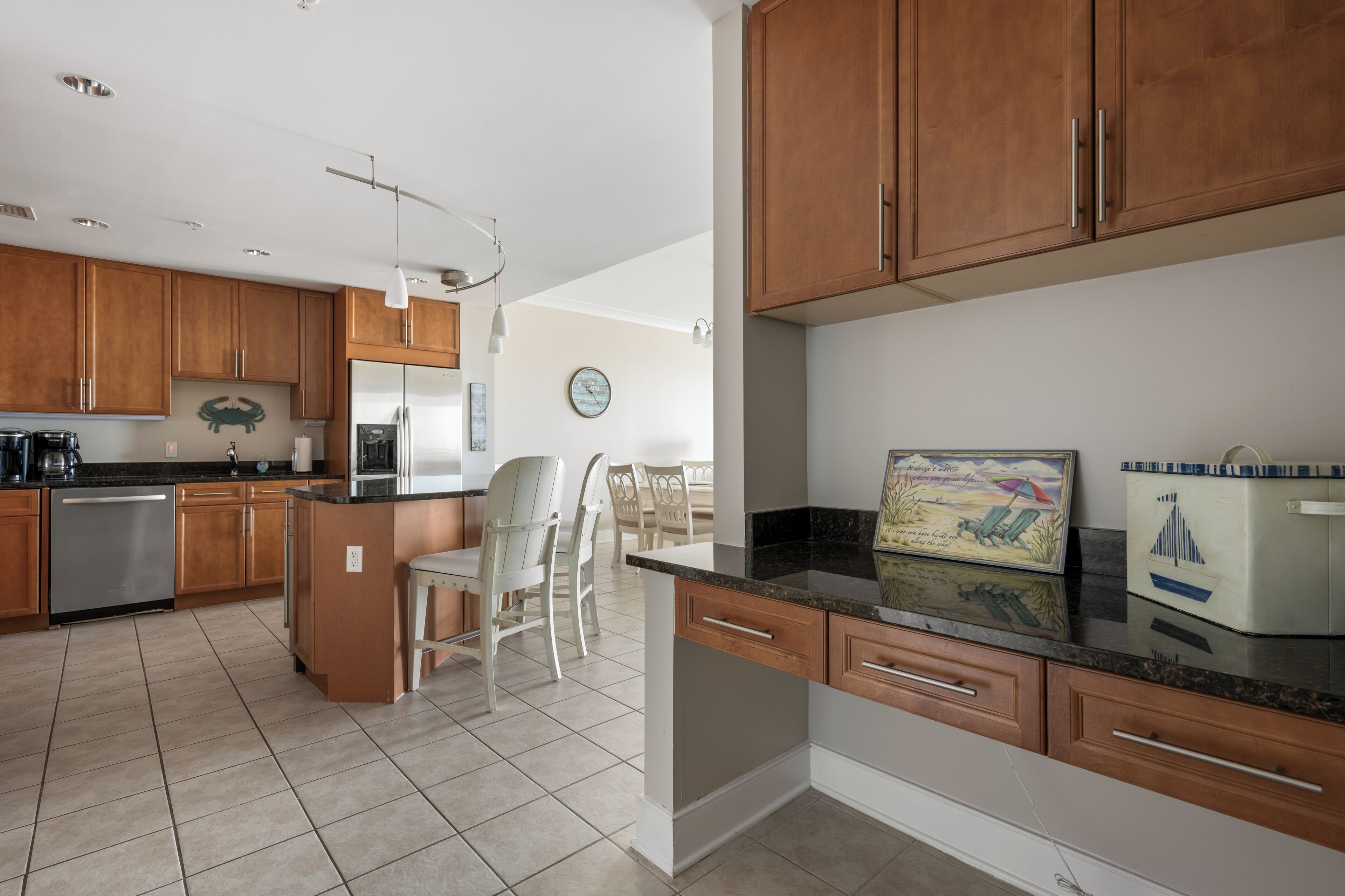Una cocina moderna con armarios de madera, una isla central y una zona de comedor con sillas.